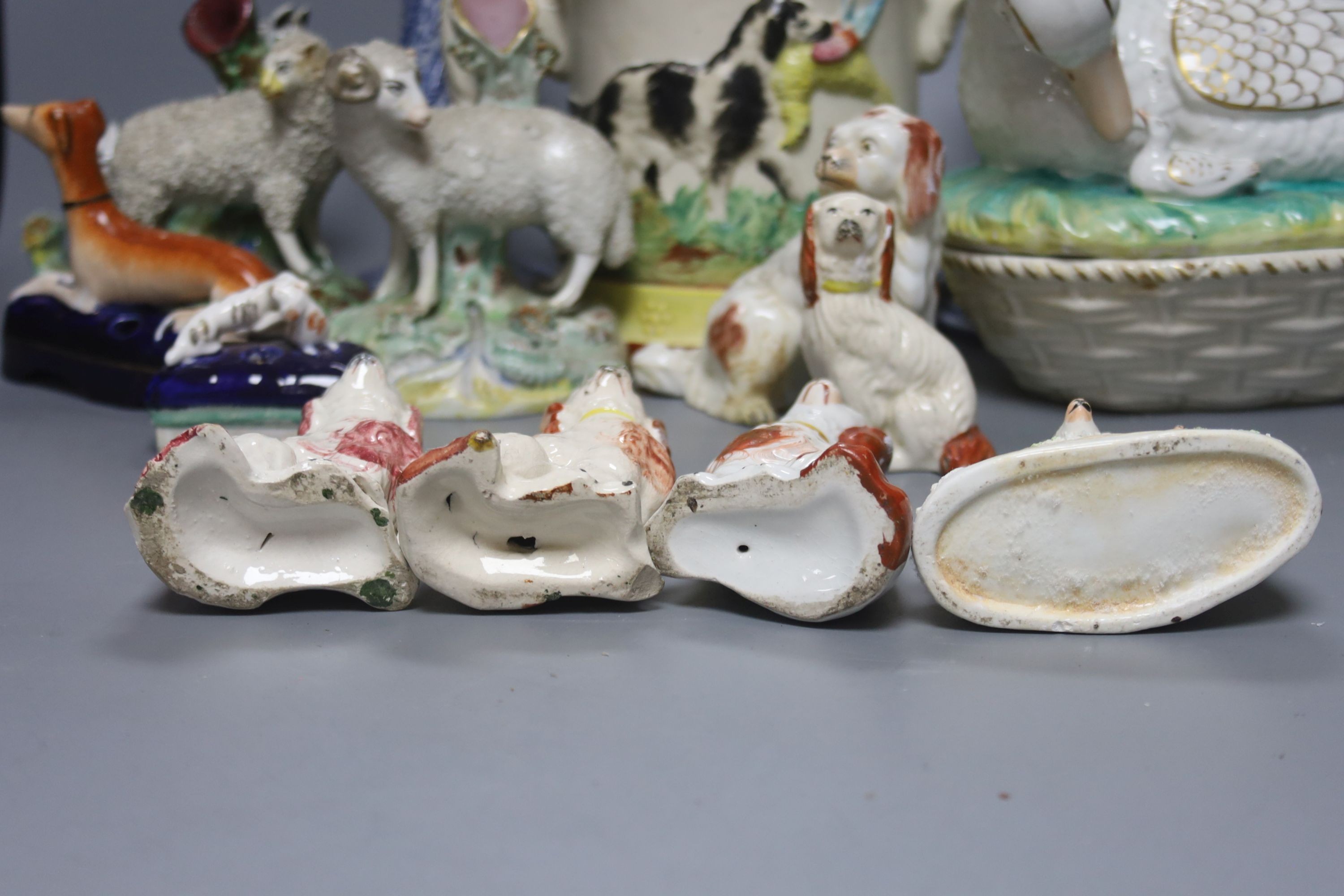 A Staffordshire pottery ‘duck’ tureen and cover, 23cm, a pair of faience candlesticks, Staffordshire figures of dogs, sheep and a zebra and a two handled loving mug